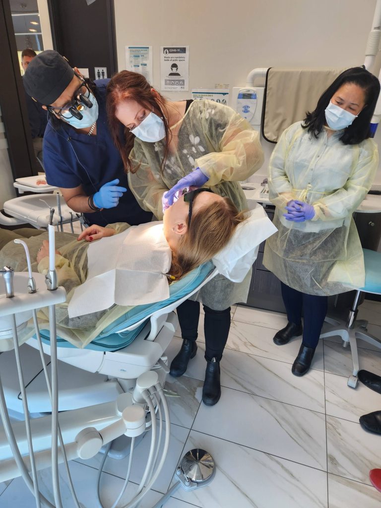 An Implant Training Group instructor guiding a delegate through a hands-on prosthodontic exercise