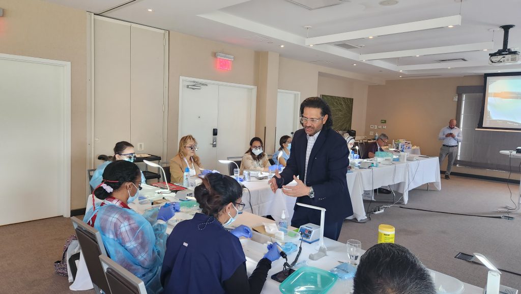 Instructor guiding delegates during a hands-on implant training session